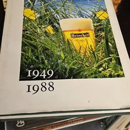 Heineken-bierposter met gras en bloemen, met jaren 1949 en 1988