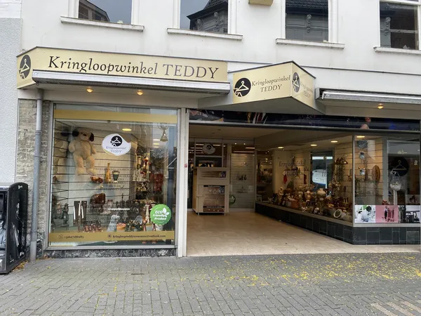 Winkelfront van Kringloopwinkel TEDDY met geel luifel, etalagevensters en ingangsdeur aan Nieuwstraat.