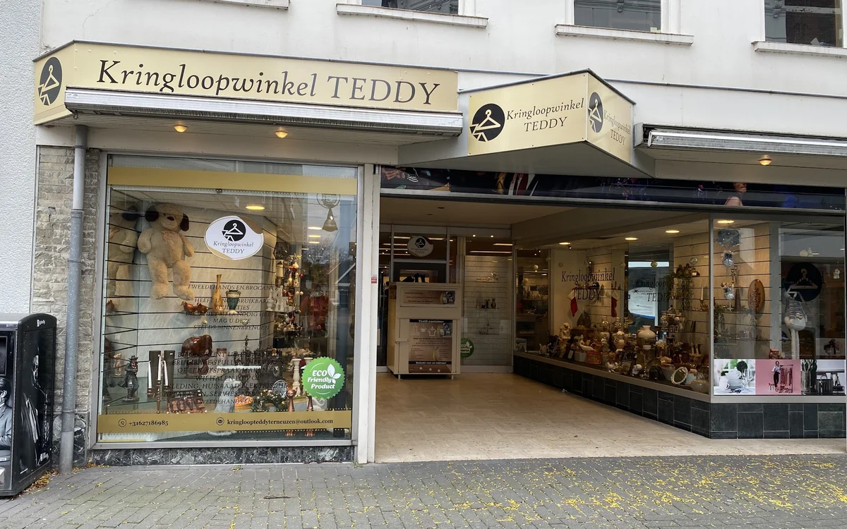 Winkelfront van Kringloopwinkel TEDDY met geel luifel, etalagevensters en ingangsdeur aan Nieuwstraat.