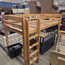 Houten stapelbedden met lattenbodem en zwarte onderkasten op uitstalling in kringloopwinkel