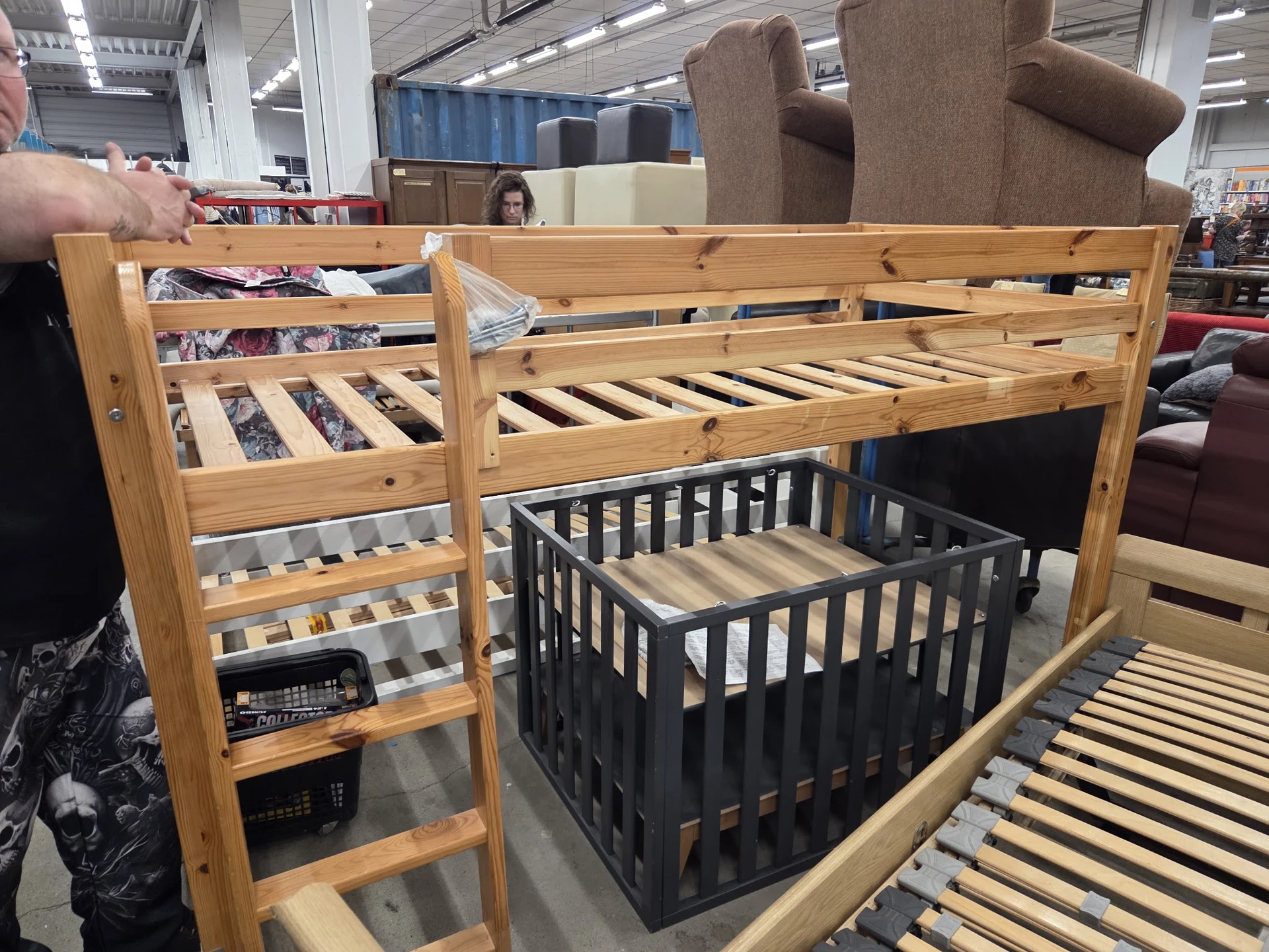 Houten hoogslaper met grijze kinderbedframe eronder en trapladder, met witte lattenramen