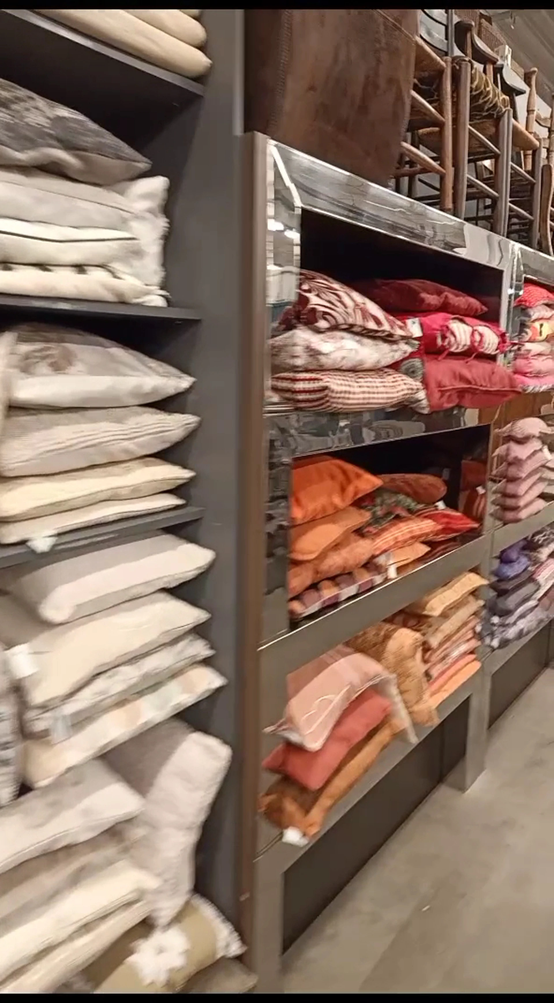 Kasten met opgestapelde witte kussens en beddengoed in verschillende kleuren