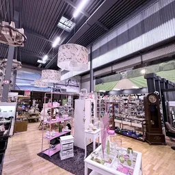 Winkelvloer met stellingen en uitgestalde spullen onder industriële verlichting