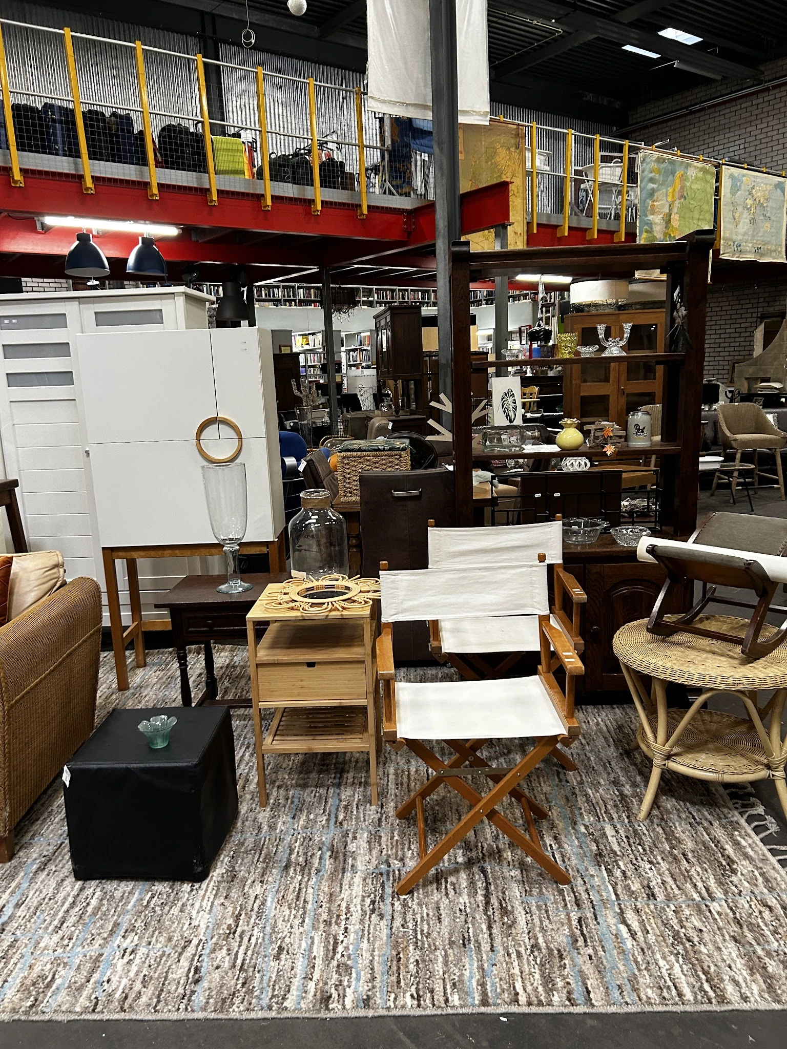 Winkelvloer met meubels: stoelen, tafels, kasten en decoratieve items uitgestald in een kringloopwinkel