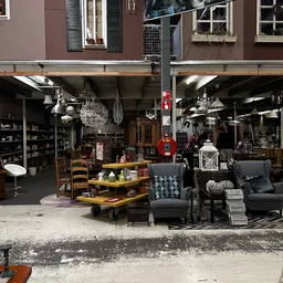 Winkelinterieur met diverse meubels, decoratie en huishoudelijke artikelen uitgestald op de begane grond