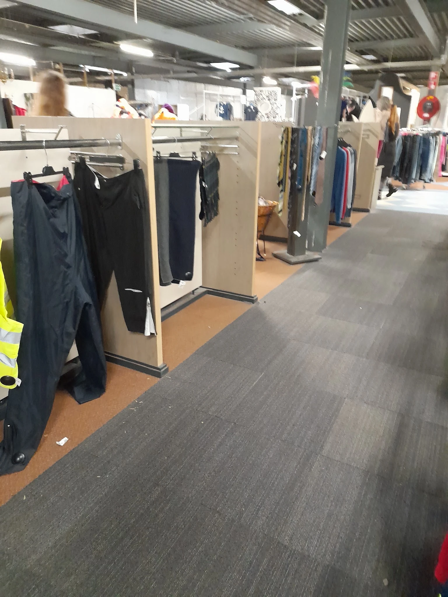 Winkelinterieur met kledingrekken en uitgestalde tweedehands kleding langs de wanden