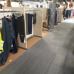 Winkelinterieur met kledingrekken en uitgestalde tweedehands kleding langs de wanden
