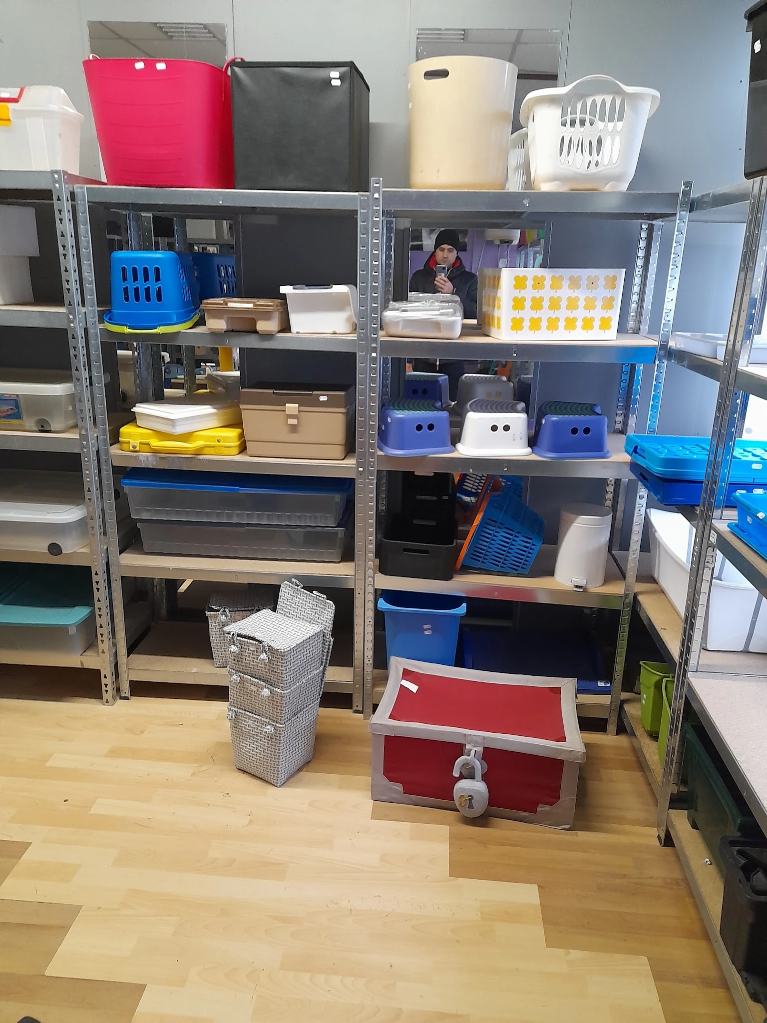 Stellingen met diverse opbergdozen, manden en kunststof bakken in verschillende kleuren