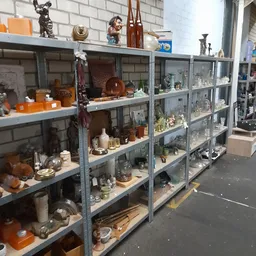 Stellingen met diverse tweedehands huishoudartikelen, servies, decoratie en voorwerpen