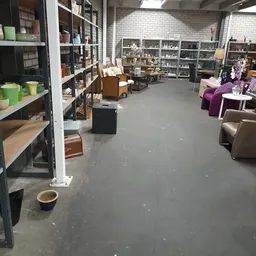 Ruim winkelbinnenland met stellingen, meubels en huishoudartikelen langs de muren en in het midden