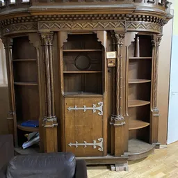 Antieke houten kast met decoratieve zuilen, spiegelwerk en open vakken voor opberging