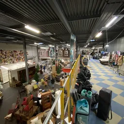 Overzicht van de winkelvloer met diverse aangeboden spullen, meubels, decoratie en kleding in een kringloopwinkel