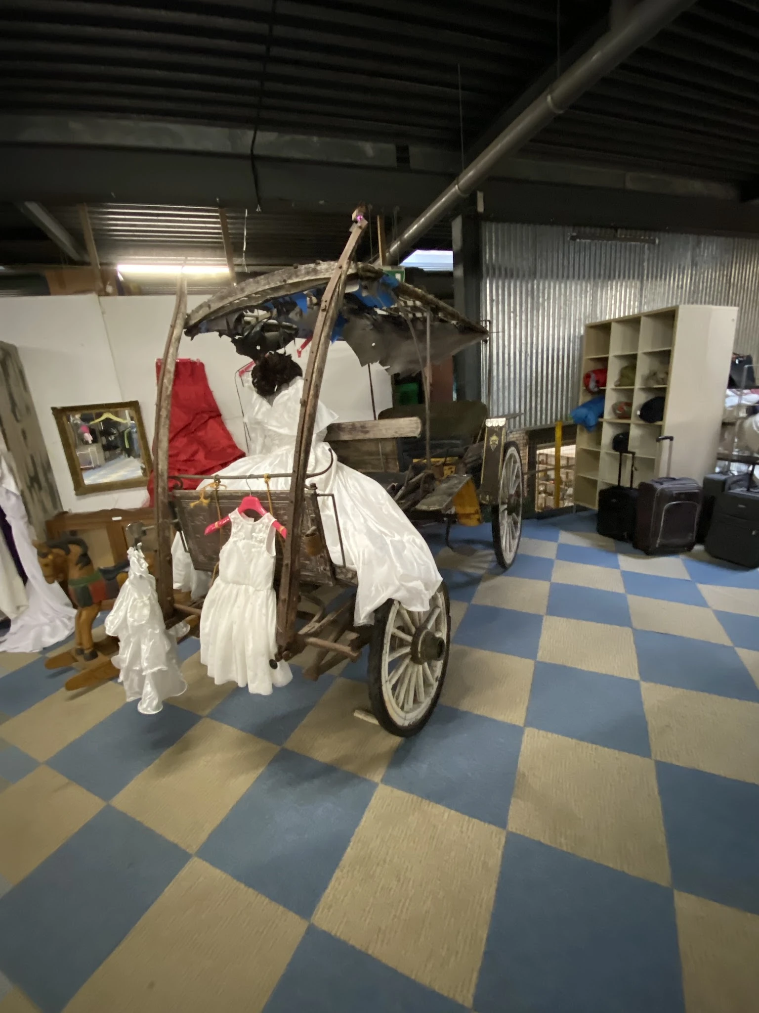 Winkelinterieur met vintage kinderwagen en diverse voorwerpen in een kringloopwinkel