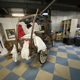 Winkelinterieur met vintage kinderwagen en diverse voorwerpen in een kringloopwinkel