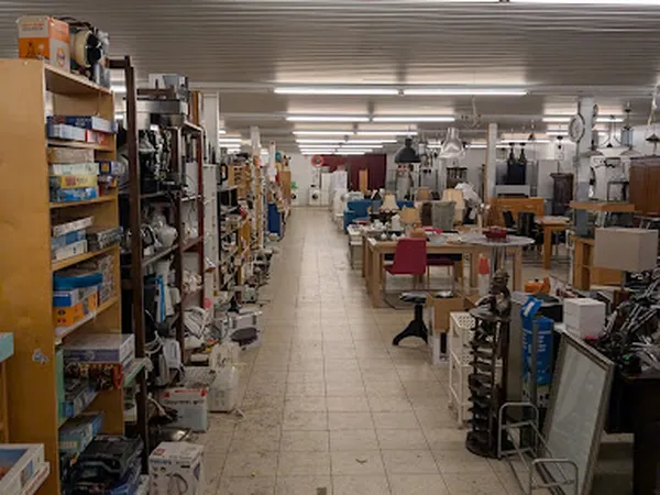 Overzicht van de winkelvloer met stellingen, rekken en uitgestalde spullen in een kringloopwinkel
