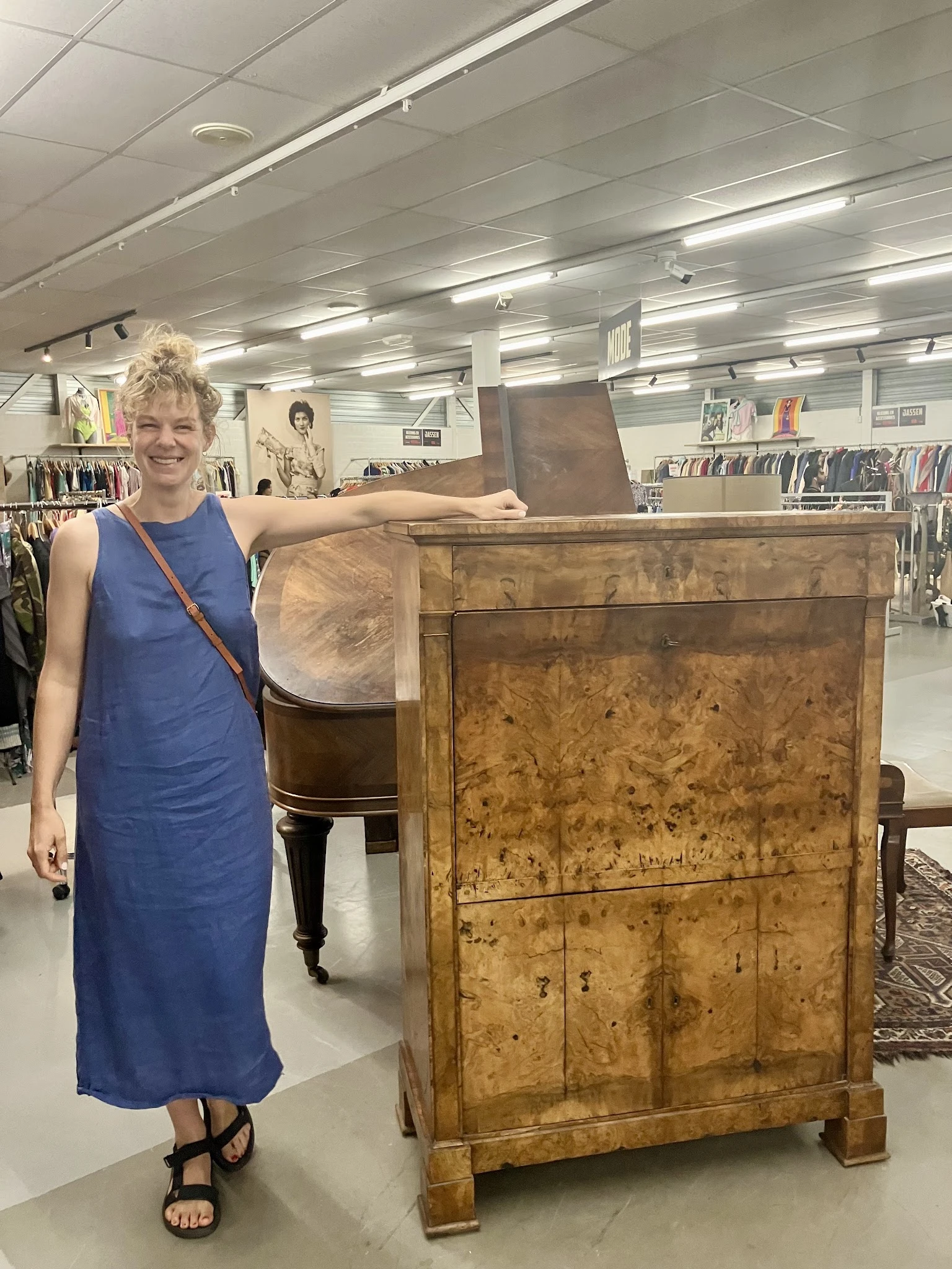 Vrouw toont houten kast met geblekte, verweerde afwerking in vintage stijl