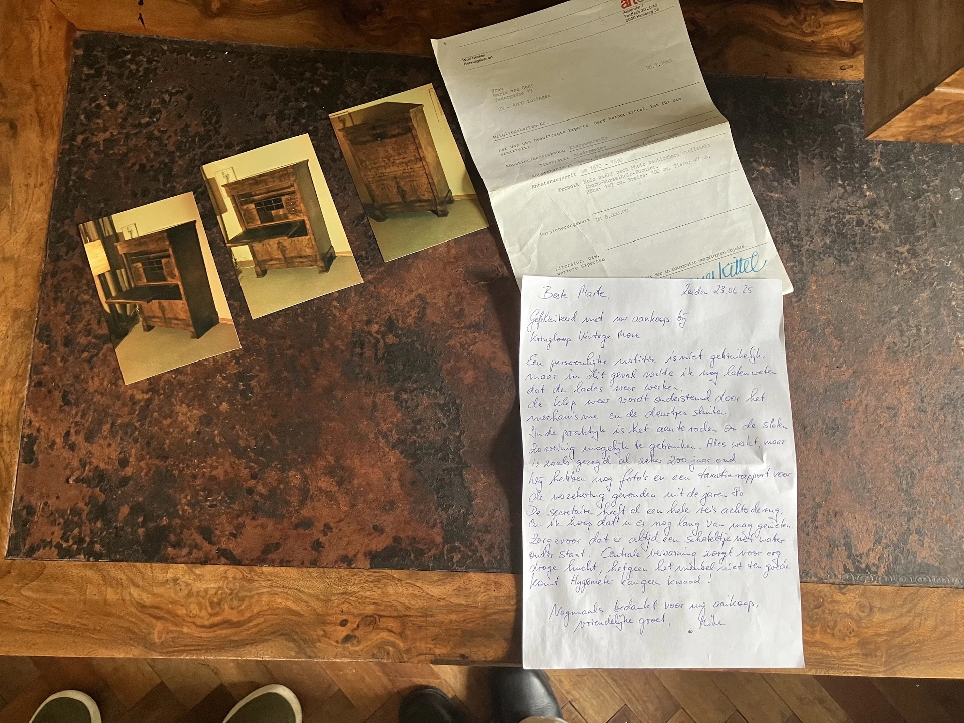 Drie gele houten miniatuurbouwsels en handgeschreven brieven op een bruine tafel