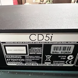Close-up van het labelpaneel van een Marantz CD5i CD-speler met serienummer en waarschuwingsteksten
