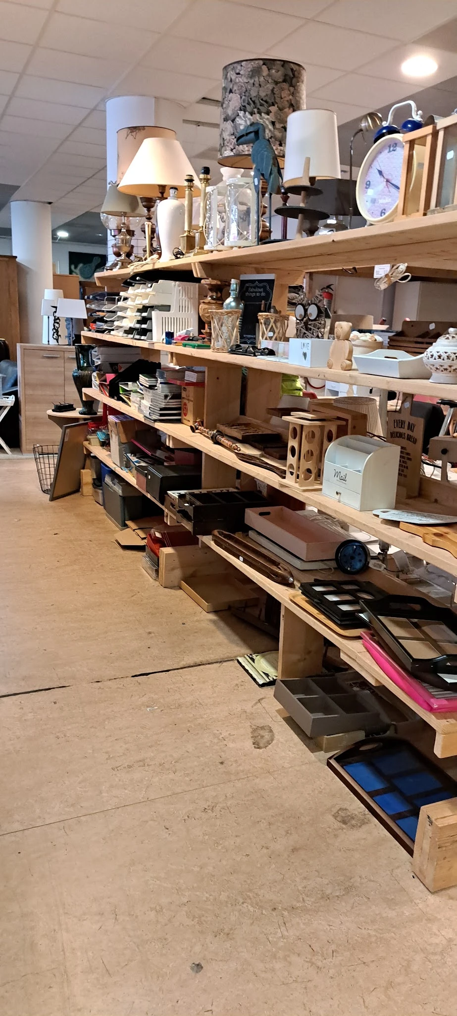 Houten stellingen met diverse artikelen in een kringloopwinkel