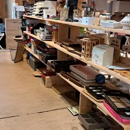 Houten stellingen met diverse artikelen in een kringloopwinkel