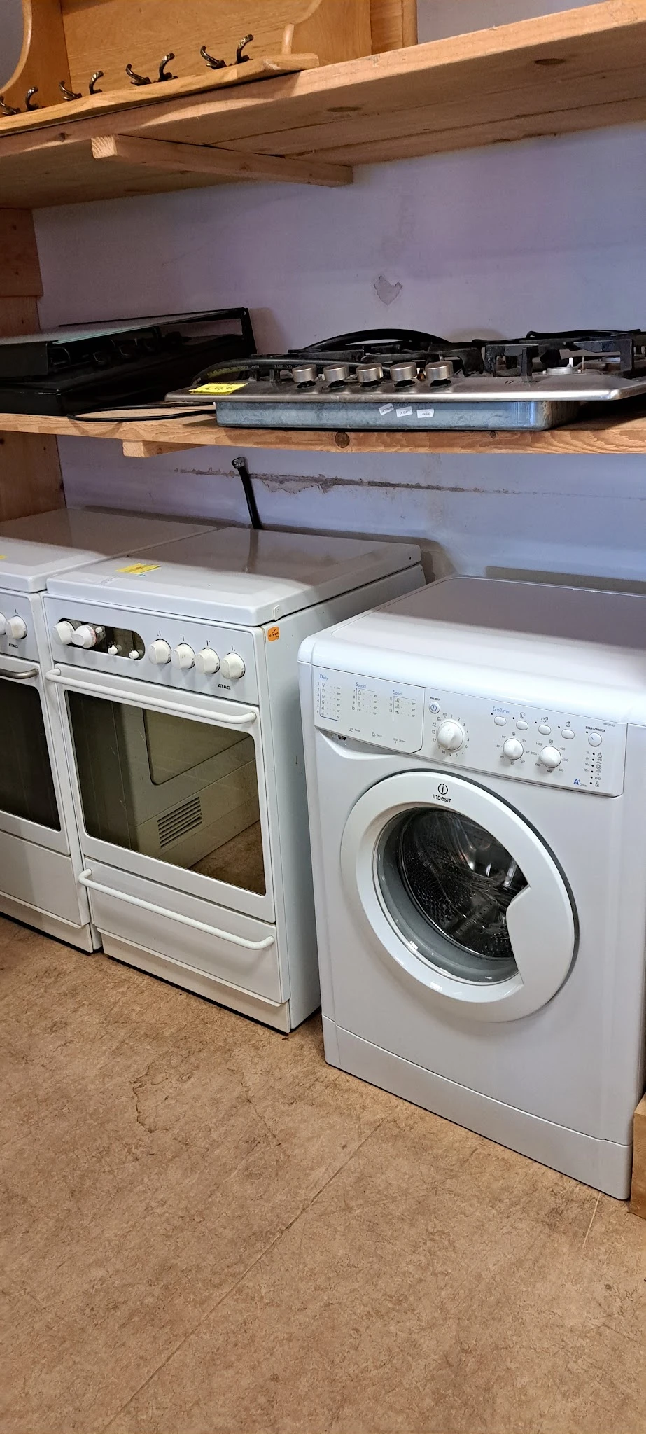 Witgoedapparaten: een elektrische oven en een wasmachine met controlekasten