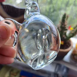 Close-up van een glazen voorwerp met waterdruppels, buiten in zonlicht