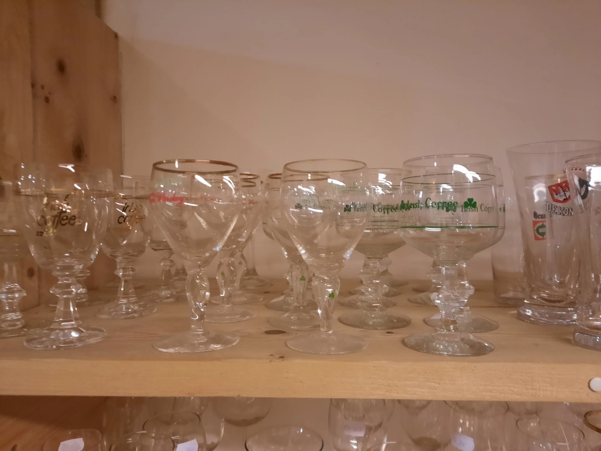 Rij glazen drinkglazen en bekers op een plank in een kringloopwinkel