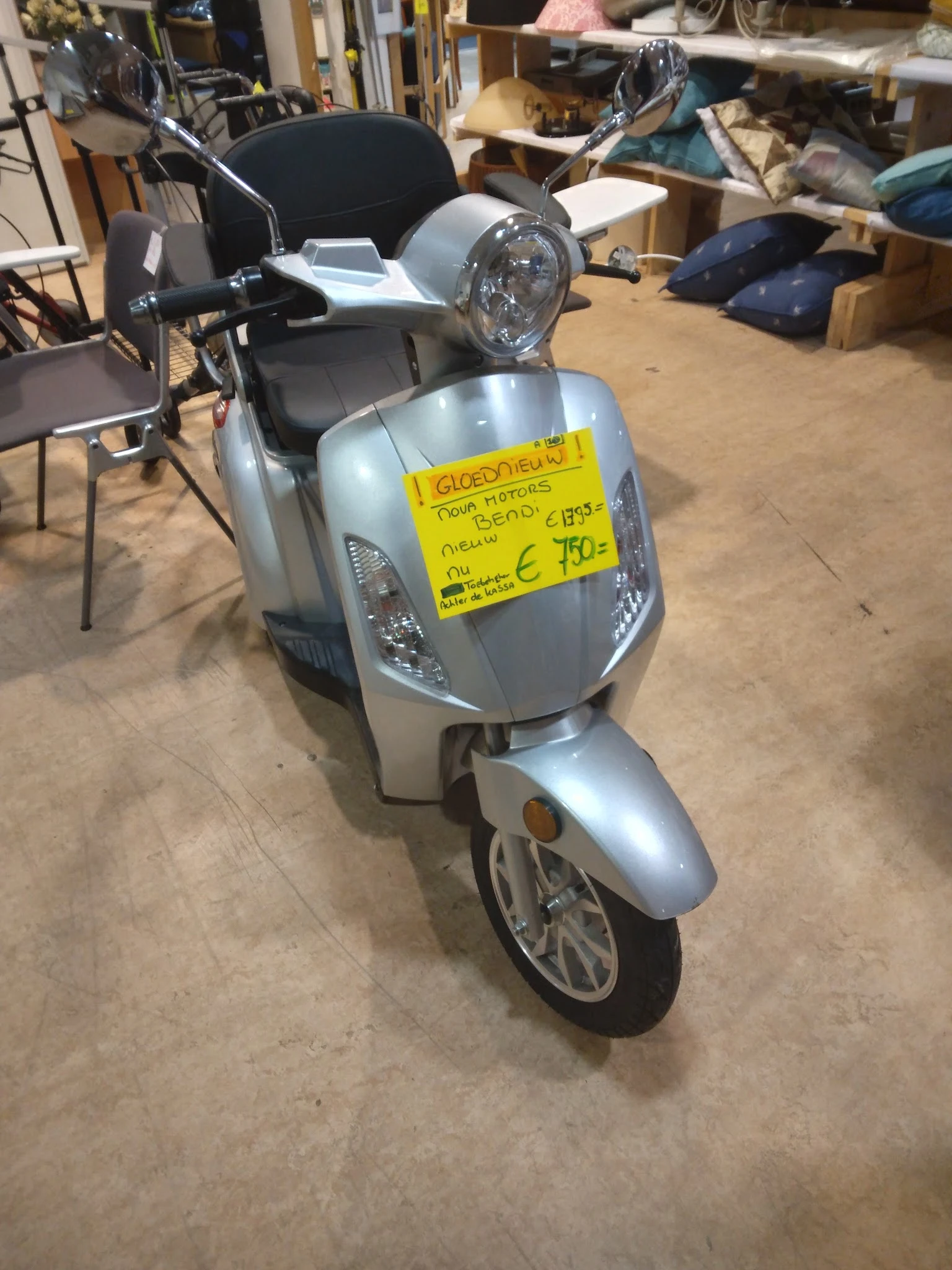 Zilvergrijze scooter met geel prijskaartje op de voorkant