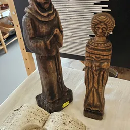 Twee houten beeldhouwwerken van vrouwenfiguren met decoratieve details