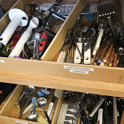 Laden met keukengerei en gereedschap, waaronder stampers, lepels en gereedschap