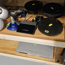 Tafel met elektronica-items zoals router, Philips-apparaat, zwarte schaal en kabels