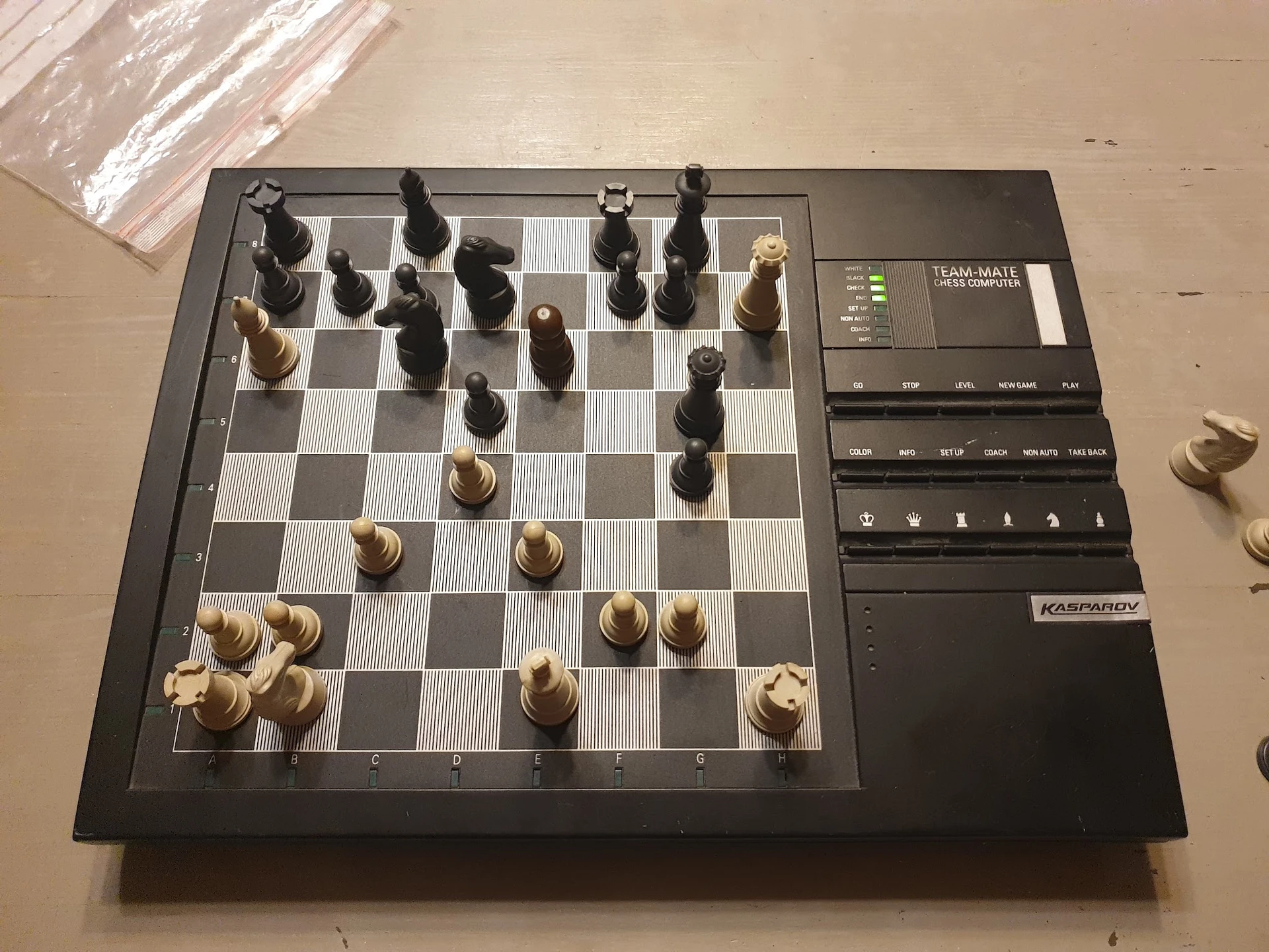 Elektronisch schaakbord met houten schaakstukken, deels opgesteld in een spelpartij