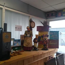 Winkelinterieur met vintage decorstukken, pop-up figuren en antieke voorwerpen op houten display