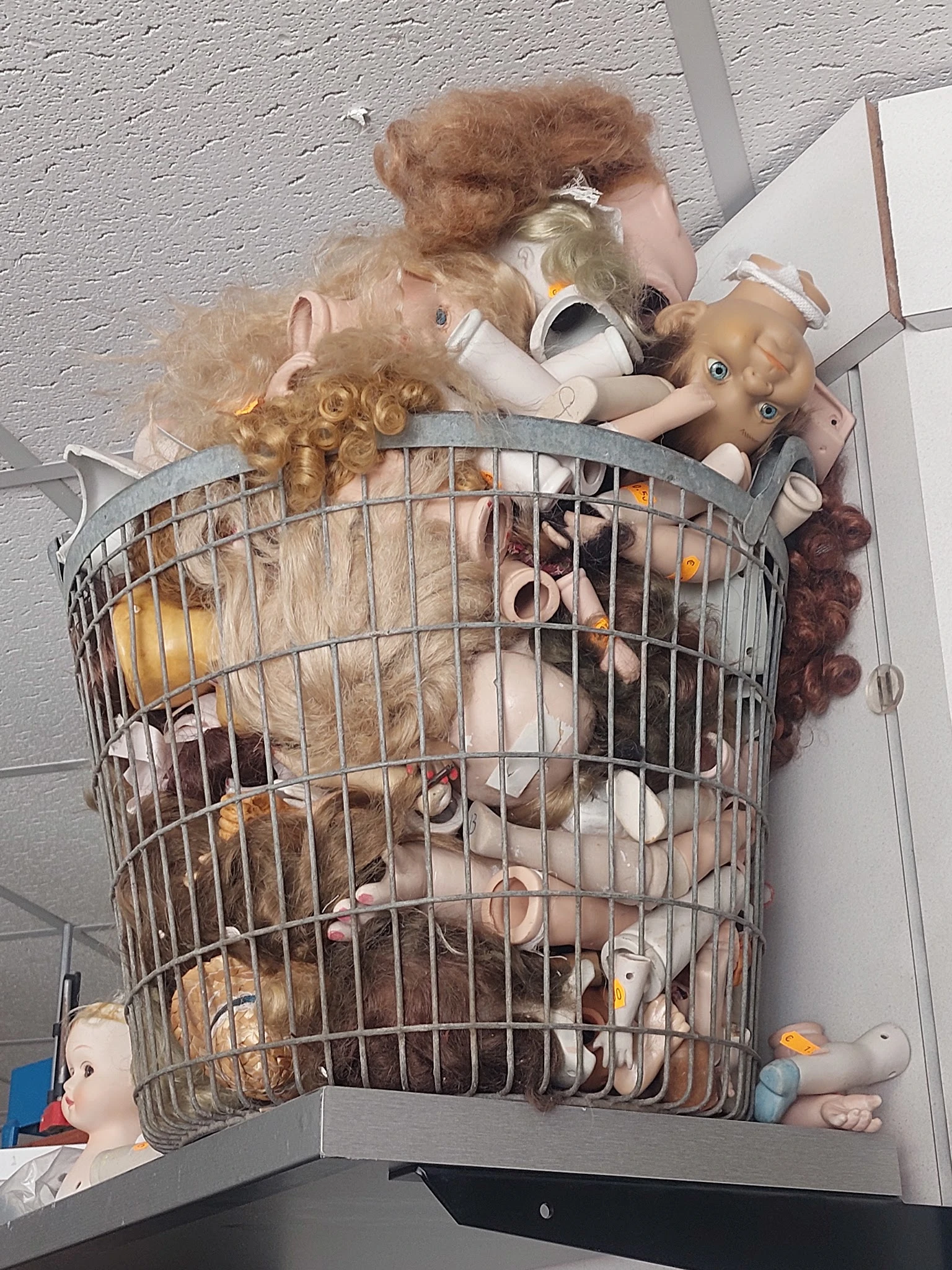Kunststoffen mand vol met speelgoed, poppen en andere tweedehands spullen
