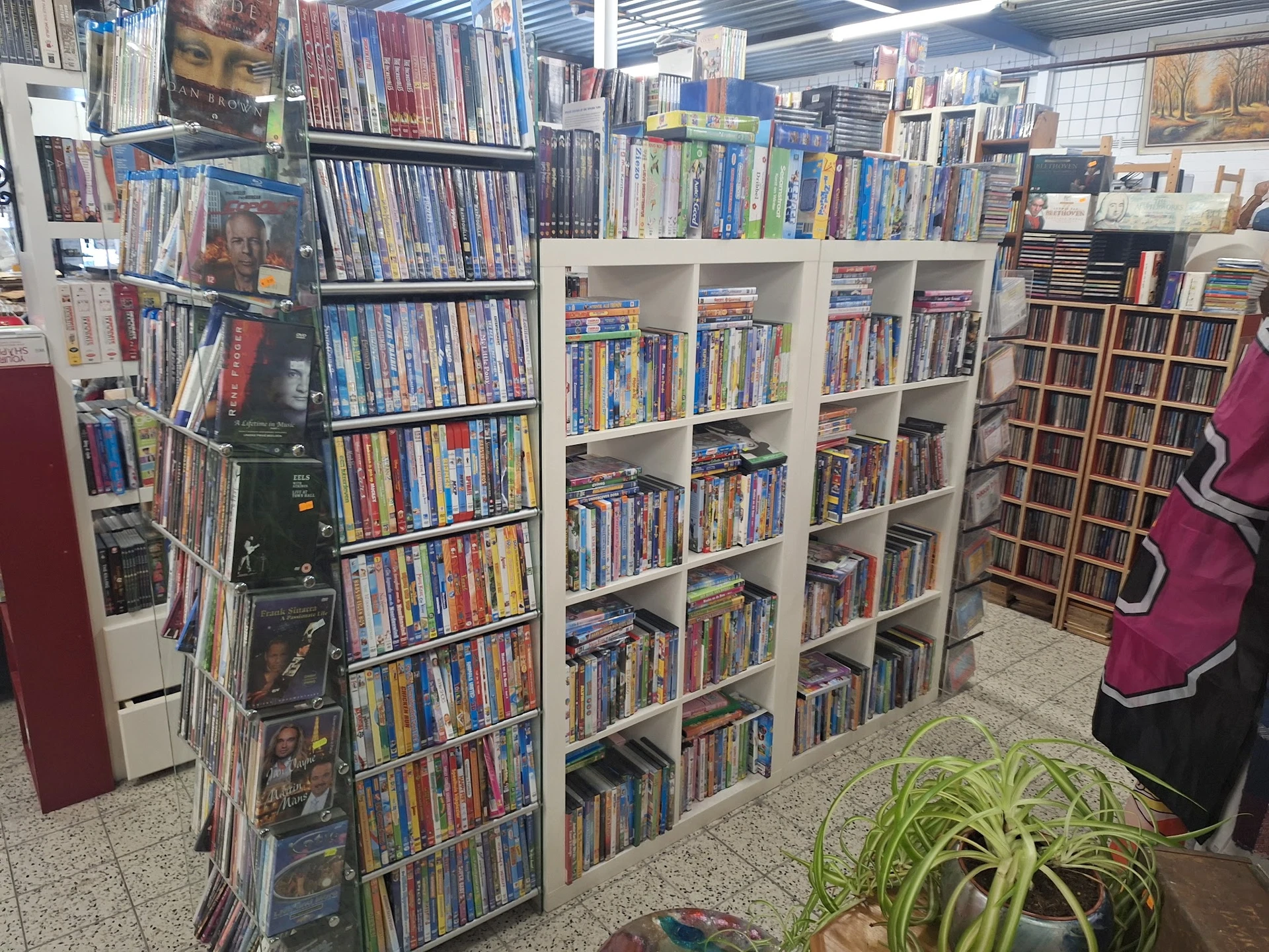 Stellingen met grote verzameling dvd's en blu-rays netjes uitgestald in de kringloopwinkel