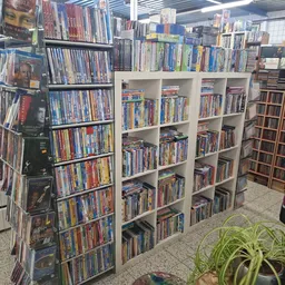 Stellingen met grote verzameling dvd's en blu-rays netjes uitgestald in de kringloopwinkel
