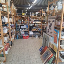 Overzicht van de winkelvloer met houten stellingen vol servies, borden, kopjes en huishoudelijke spullen