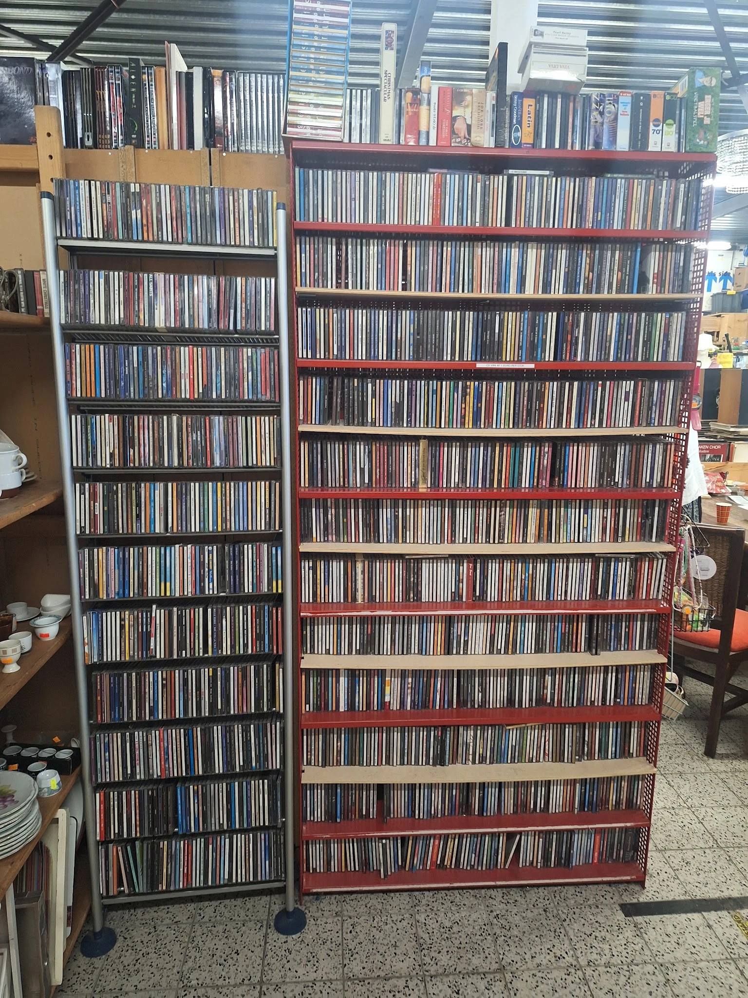 Grote stellingen met honderden CD's en DVD's netjes uitgestald in plastic hoezen