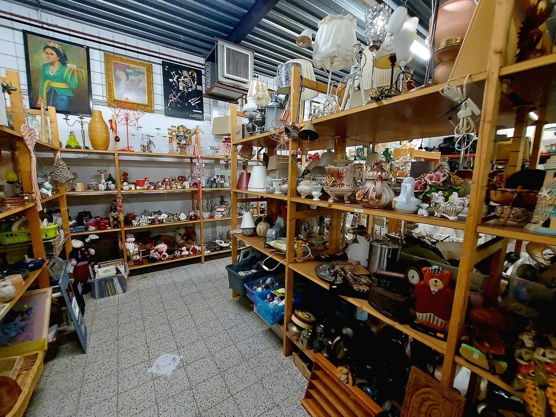 Winkelinterieur met houten stellingen vol decoratieve artikelen, beeldjes en verzamelobjecten