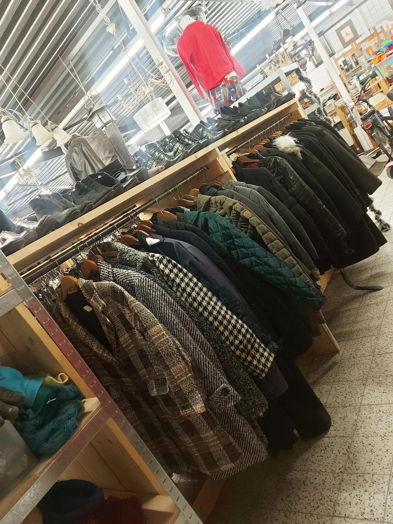 Rekken met tweedehands jassen en winterkleding in verschillende kleuren