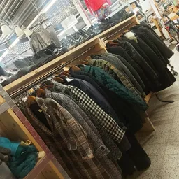 Rekken met tweedehands jassen en winterkleding in verschillende kleuren