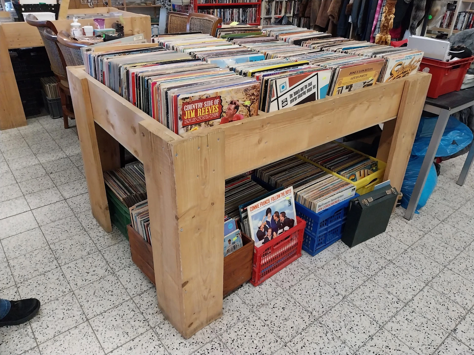 Houten display met tweedehands vinyl records, cd's en dvd's uitgestald op meerdere niveaus