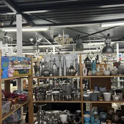 Houten kasten met uitgestalde huishoudelijke artikelen zoals pannen, servies en keukengereedschap