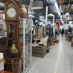 Winkelvloer met verschillende afdelingen: vintage klok, kleding aan rekken, huishoudelijke spullen en decoratie op verschille