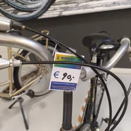 Close-up van een fiets met een prijskaartje van €9,- eraan bevestigd