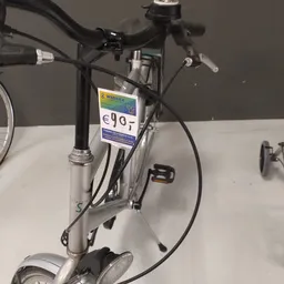 Zilveren herenfietsen met prijskaartje van 90 euro op verkooptafel