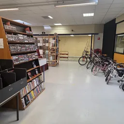 Winkelvloer met boekenkasten, fietsen en kinderwagens in een kringloopwinkel