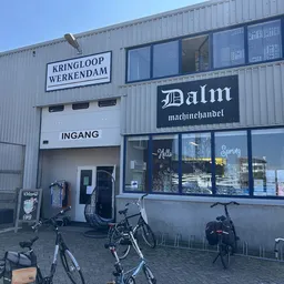 Gevel van Kringloop Werkendam met ingang, ramen en fietsen ervoor geparkeerd