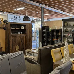 Winkelvloer van kringloopwinkel met meubels, kasten, lampen en diverse huishoudelijke spullen uitgestald