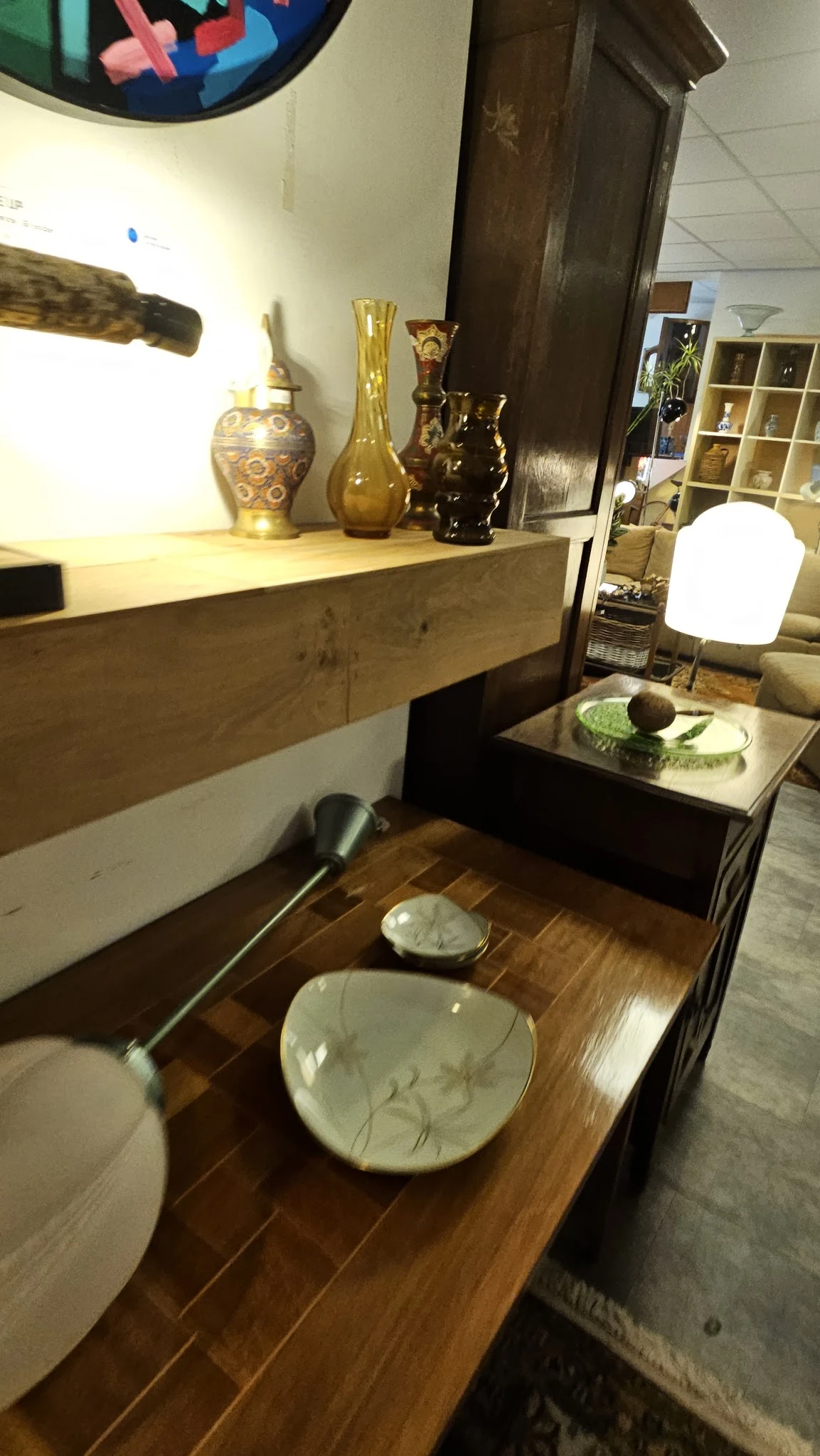 Woonkamerinrichting met houten meubels, decoratieve objecten en verlichting in een kringloopwinkel